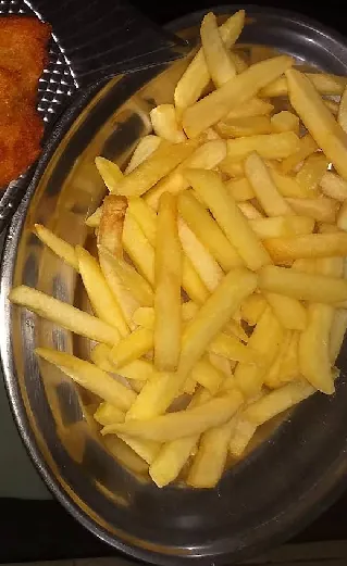 Porção de batata frita dourada em tigela de inox